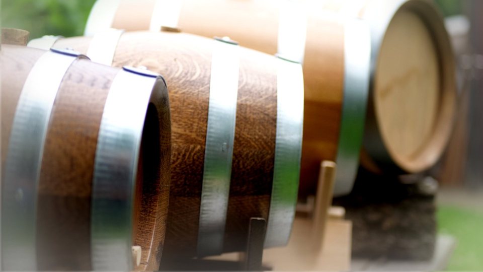 Mehrere Whiskyfässer unterschiedlicher Größe nebeneinander aufgereiht